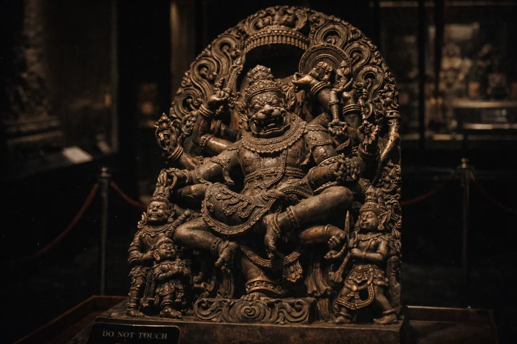 * Close-up of a weathered metal statue depicting the death of a king by a lion-man.