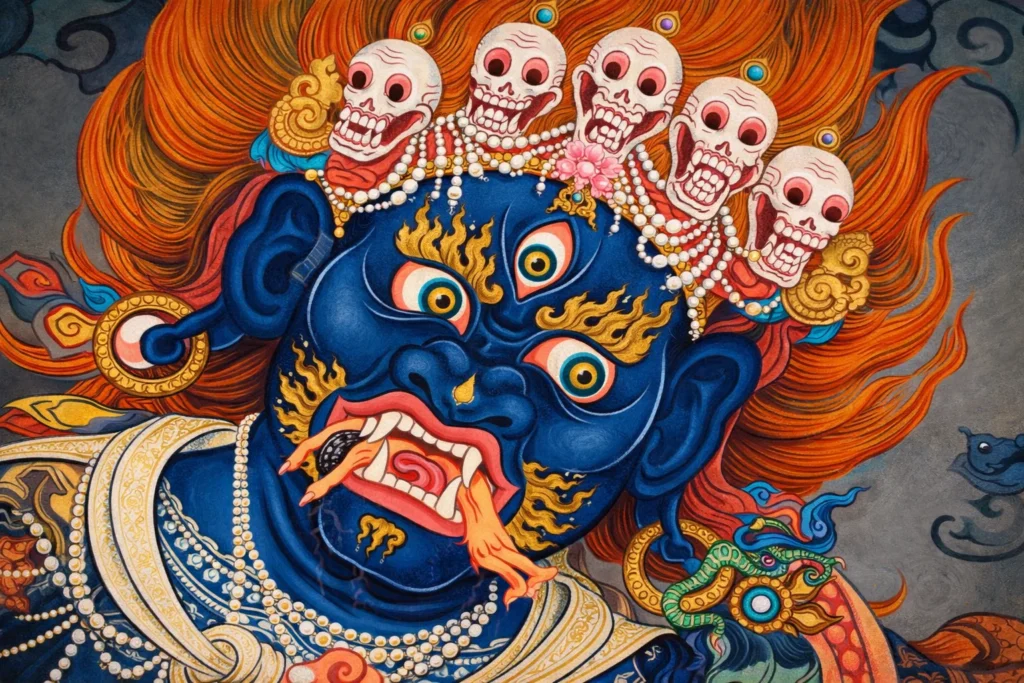Close-up of a blue wrathful deity’s face with three eyes and a skull crown.